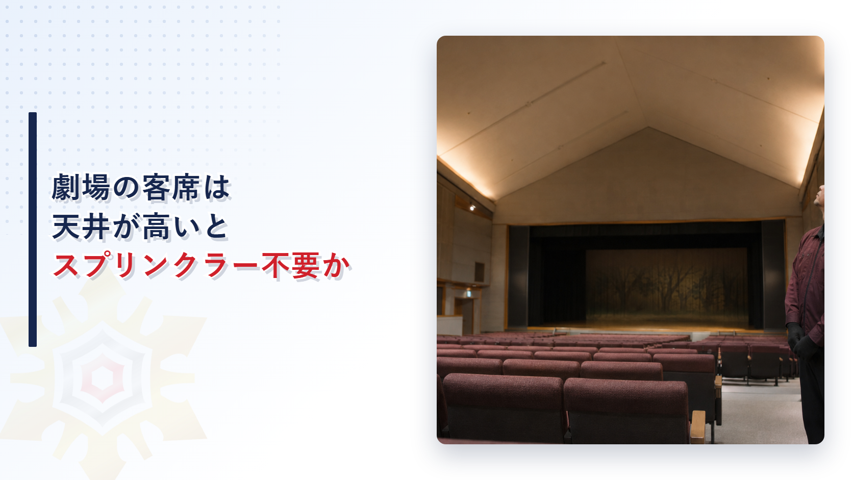 天井の高い劇場客席で防火管理者が天井を見上げている写真