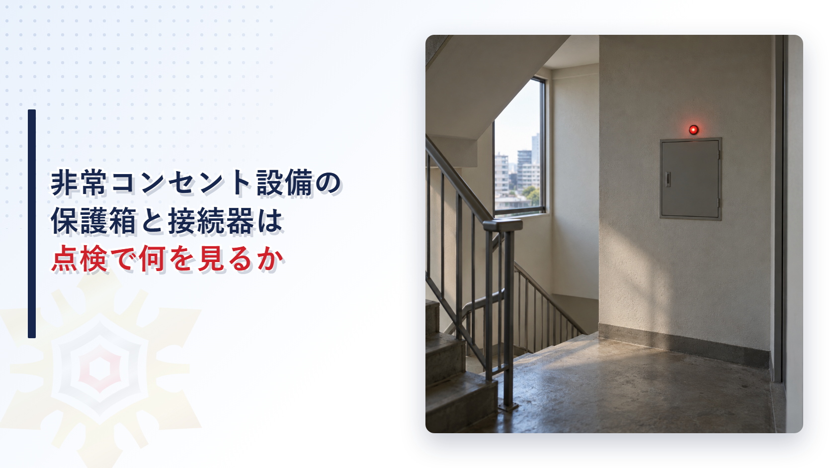 階段の踊り場の壁に、赤い表示灯が点いた埋込みの灰色の保護箱が付いている写真