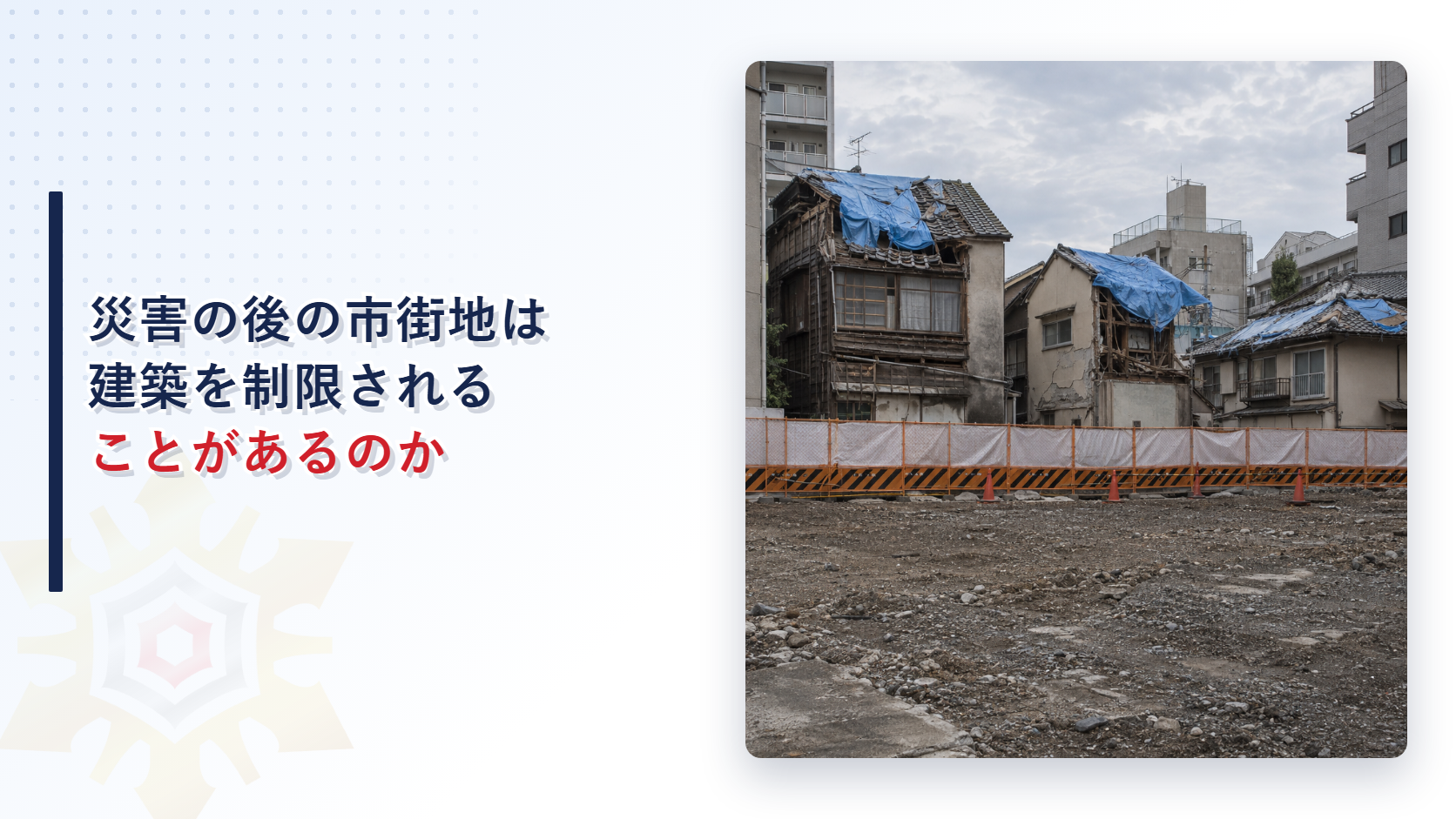 災害で被災した建物の前に工事用の囲いが立つ市街地の写真