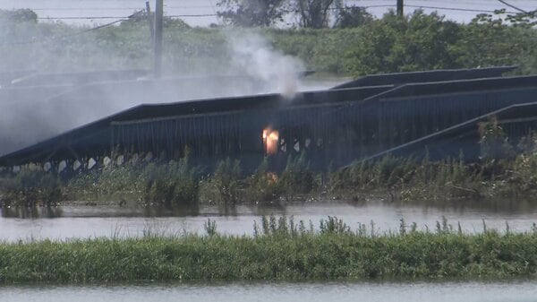 冠水した太陽光発電施設から煙と炎が上がる様子