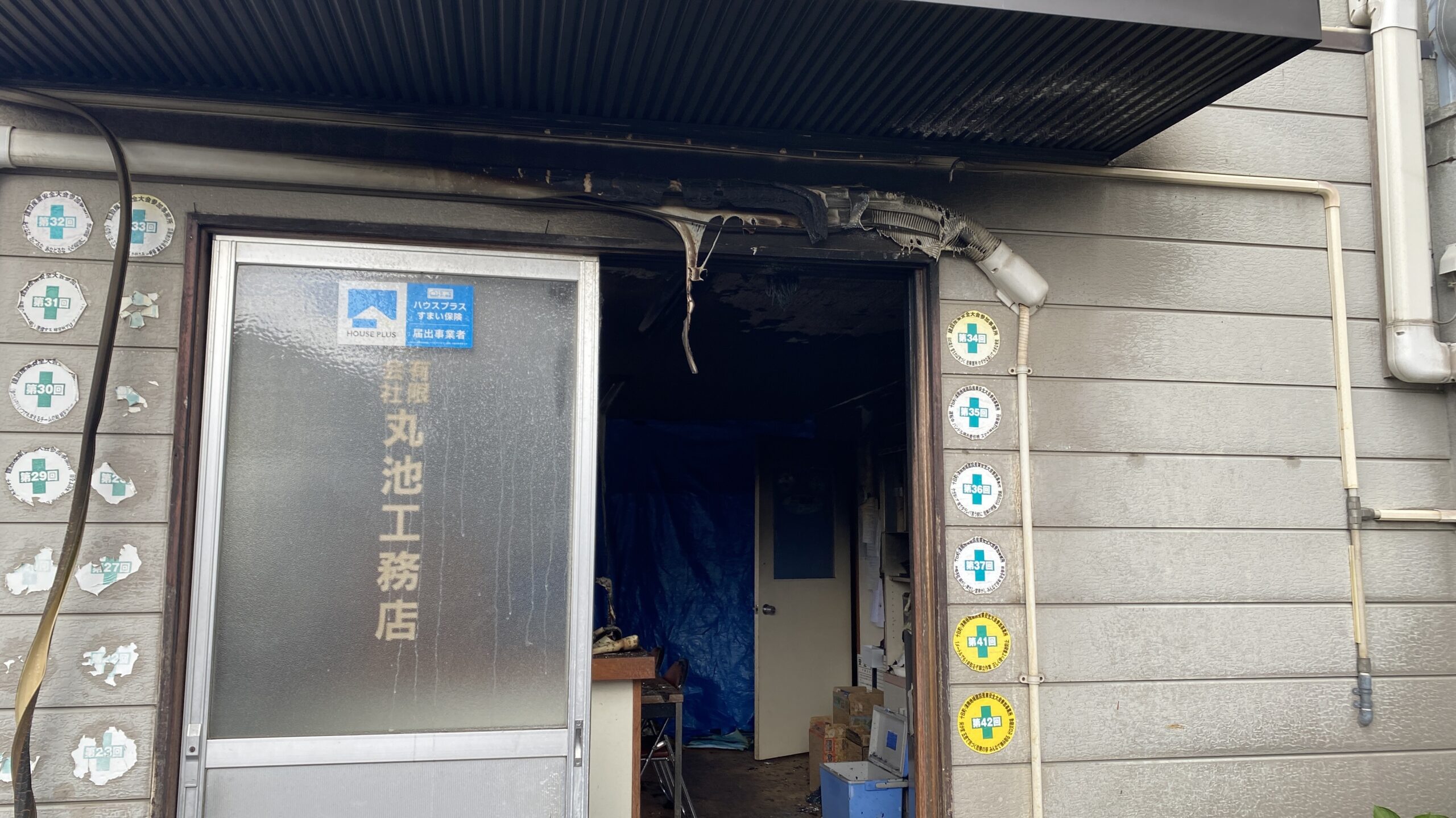 十日町市の工務店火災後、焼損した事務所入口を写した現場写真